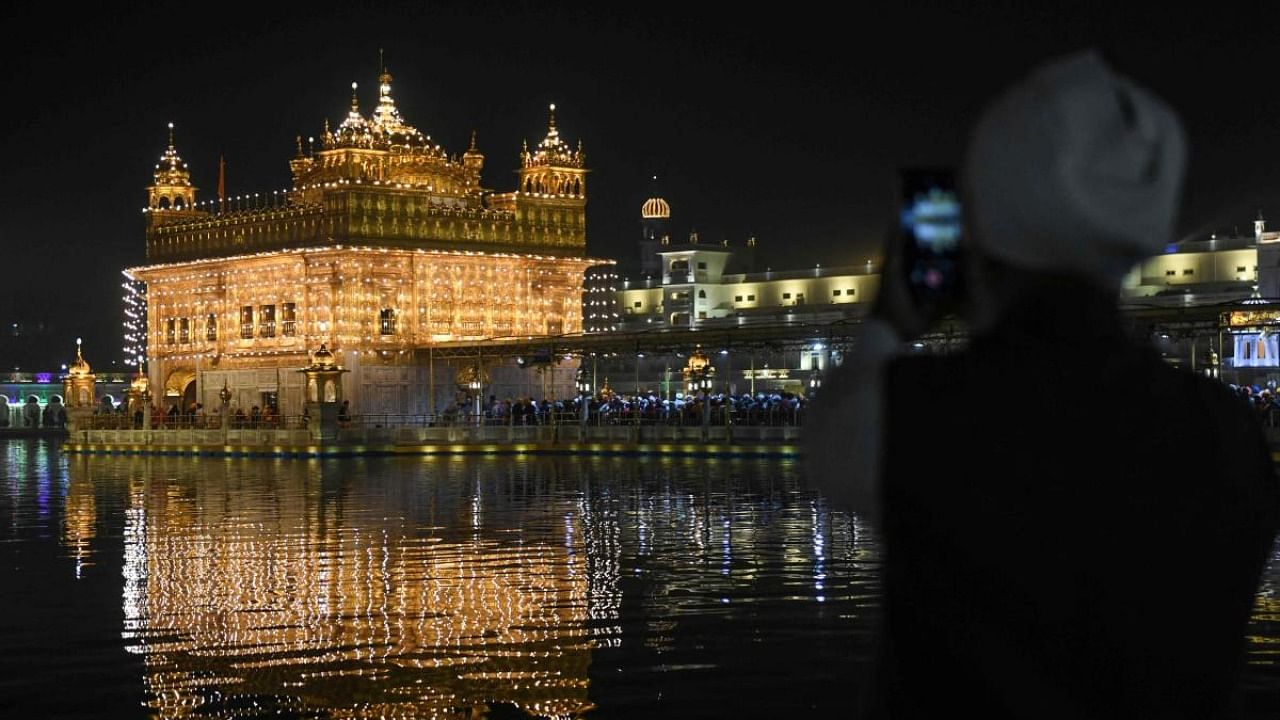 Sikh devotees pay their respects on the eve of the birth anniversary of Guru Nanak, founder of Sikhism, at the Golden Temple in Amritsar. Credit: AFP Photo