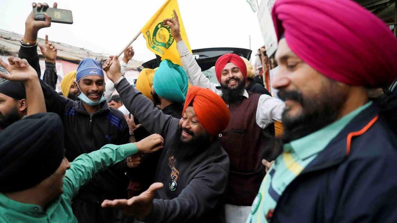 Farmers celebrate after Indian PM Modi announced that he will repeal the controversial farm laws, near Delhi-Haryana border. Credit: Reuters Photo