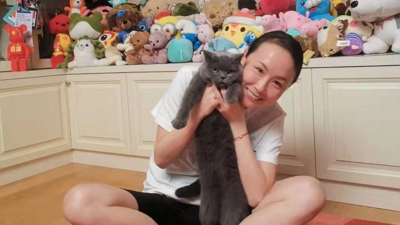 One photo shows the smiling player with a cat in her arms, with stuffed animals, a trophy, a Chinese flag and certificates visible in the background. Credit: Twitter/@shen_shiwei