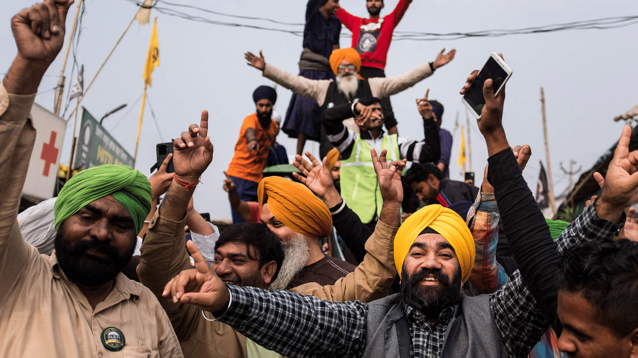 Farmers celebrate after India's Prime Minister announced to repeal three agricultural reform laws that sparked almost a year of huge protests by farmers across the country in Singhu. Credit: AFP Photo
