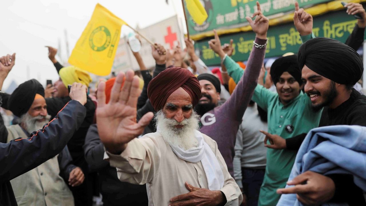 Farmers celebrate at the Singhu border in Delhi. Credit: Reuters Photo