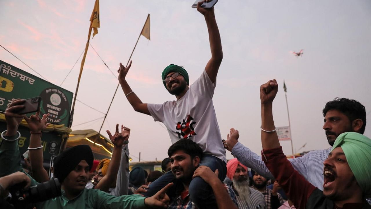 Farmers celebrate after Prime Minister Narendra Modi announced that he will repeal the controversial farm laws, at the Singhu border farmers protest site near Delhi-Haryana border, India. Credit: Reuters Photo