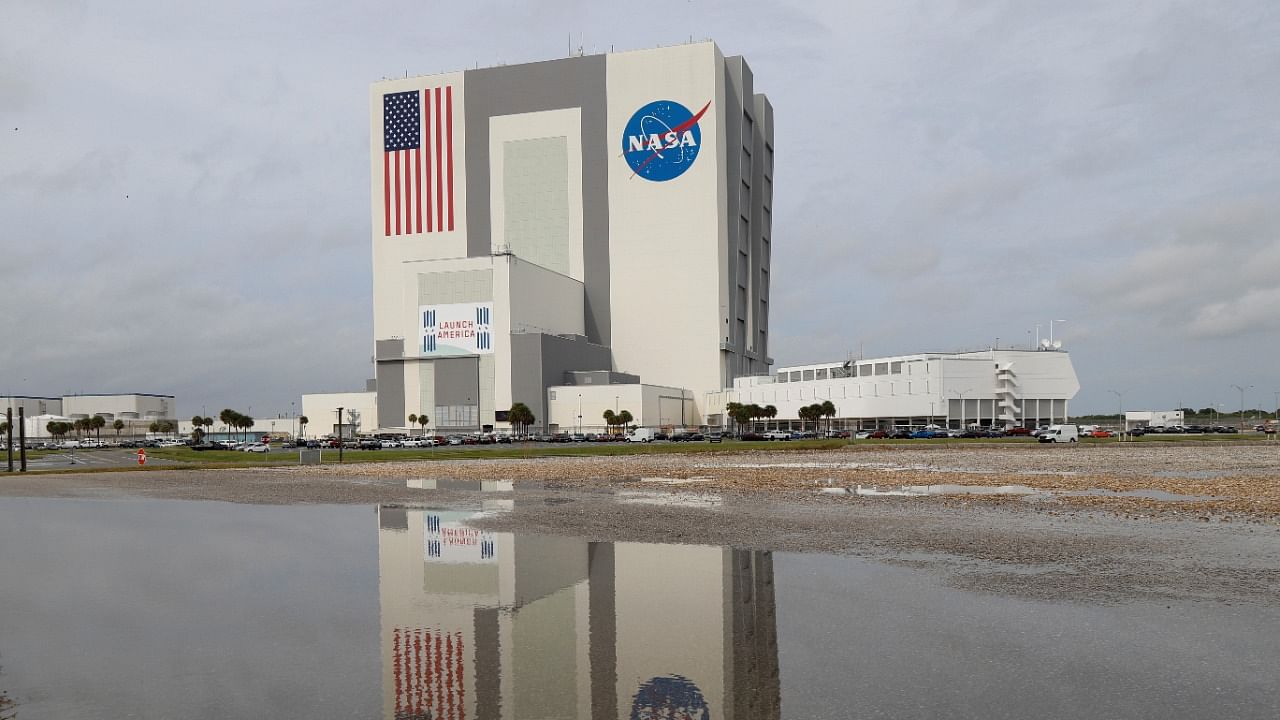 The massive Vehicle Assembly Building where NASA’s powerful new 322-foot-tall moon rocket has been assembled for the unpiloted Artemis 1 mission, is reflected after a hard rain at the Kennedy Space Center in Cape Canaveral, Florida. Credit: Reuters File Photo
