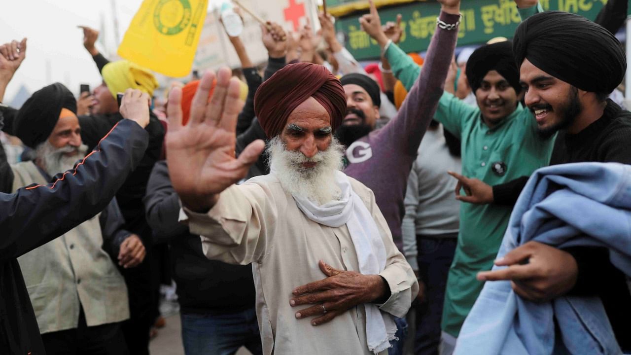 Farmers celebrate after PM Modi announced that he will repeal the farm laws, at the Singhu border in Delhi. Credit: Reuters File Photo