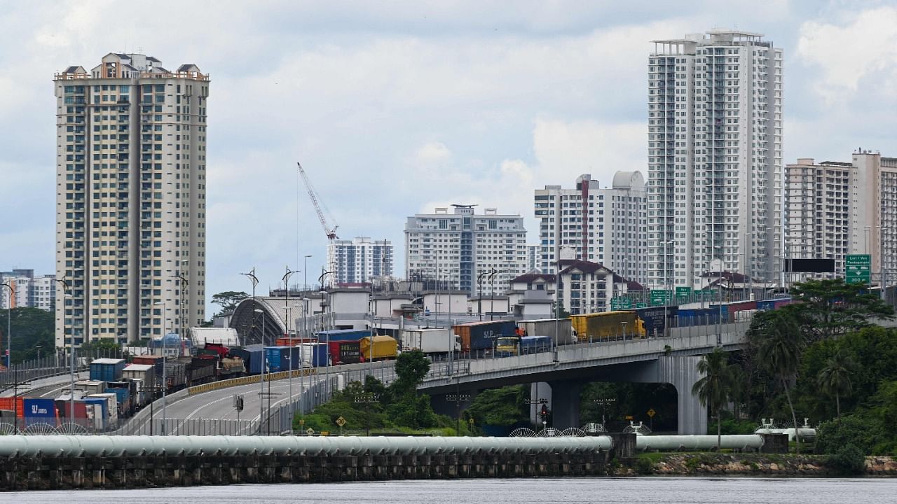 A queue of trucks wait to return to Malaysia's Johor on a causeway link after delivery in Singapore. Credit: AFP File Photo