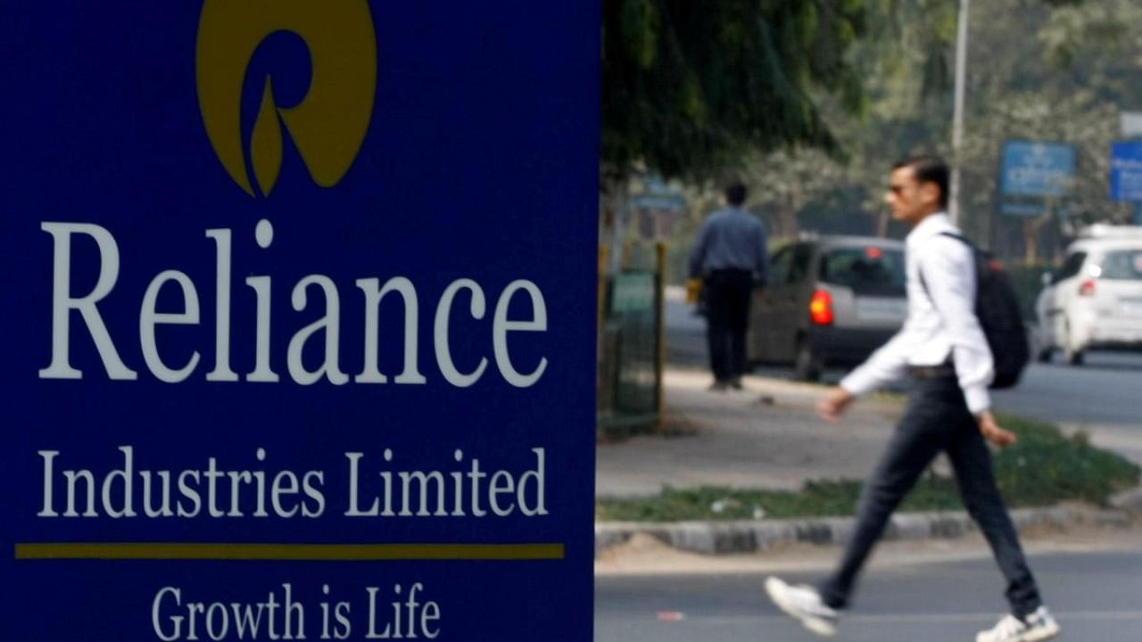  A man walks past a Reliance Industries Limited sign board installed on a road divider in Gandhinagar. Credit: Reuters Photo