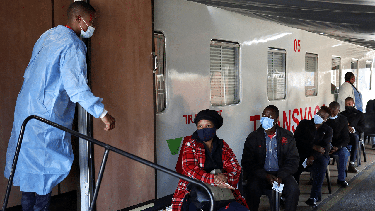 A health worker talks to people as they wait to register next to the Transvaco coronavirus disease vaccine train, after South Africa. Credit: Reuters Photo