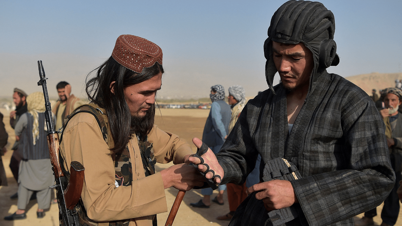 Taliban fighter Osama (L) helping Taliban leader Abu Do Jana. Credit: Reuters Phot