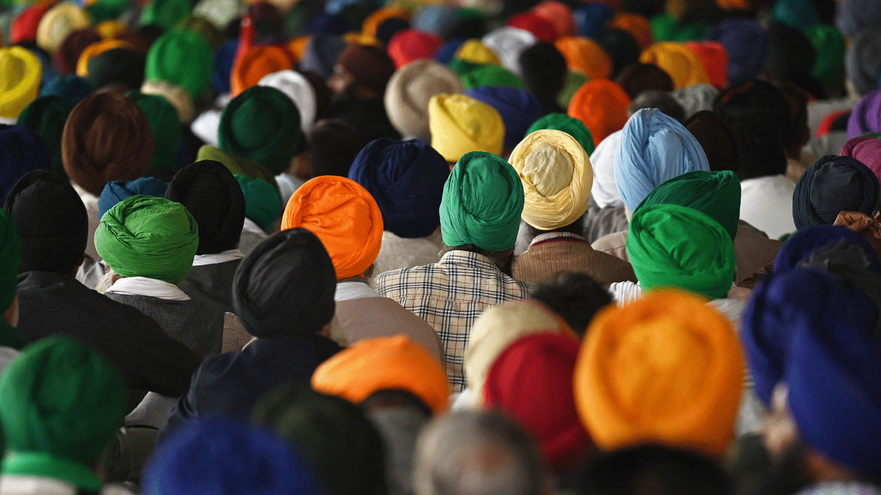 Farmers listen to a speaker on the occasion of the first anniversary of the farmers' protests against the central government's agricultural reform laws at the Delhi-Haryana state border in Singhu. Credit: AFP Photo
