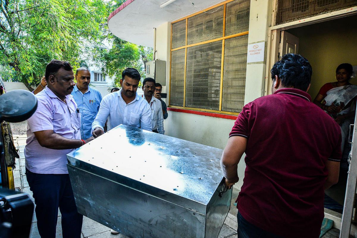 Gold jewellery, cash and documents pertaining to movable and immovable assets seized from the premises of Jewargi PWD JE Shantagouda Biradar, are being taken in a trunk to deposit the same at government treasury in Kalaburagi. Credit: DH Photo