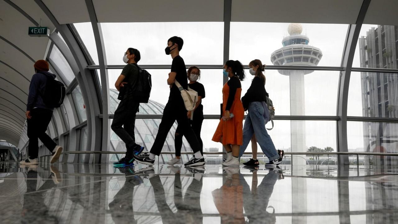People pass the control tower of Singapore's Changi Airport. Credit: Reuters photo
