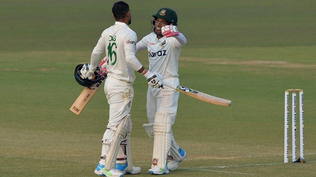Liton Das (L) is congratulated by teammate Mushfiqur Rahim after he scored a century (100 runs) during the first day of the first Test cricket match between Bangladesh and Pakistan. Credit: AFP Photo