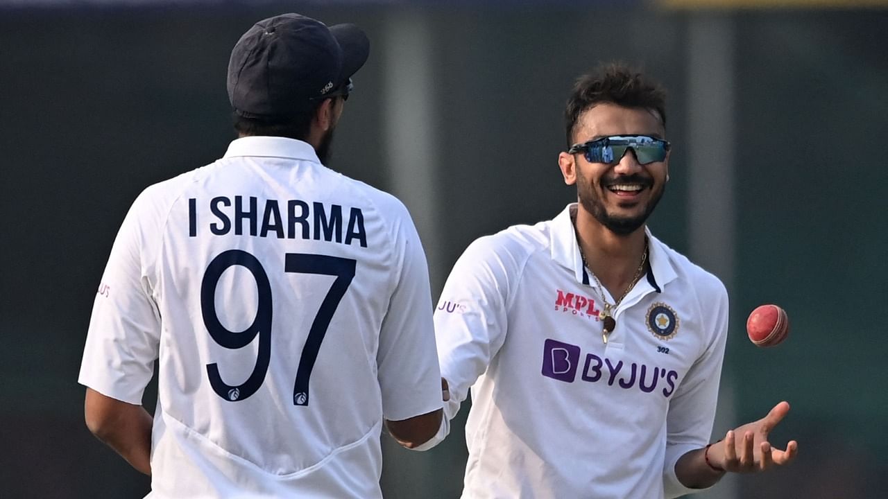 Axar Patel (R) celebrates with teammate Ishant Sharma after taking the wicket of New Zealand's Tim Southee (not pictured) on the third day of the first Test cricket match between India and New Zealand at the Green Park Stadium in Kanpur. Credit: AFP Photo