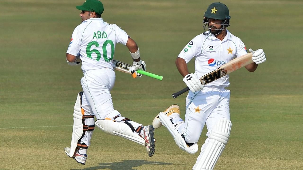 Pakistan's Abid Ali (L) and teammate Abdullah Shafique run between the wickets on the second day of the first Test cricket match between Bangladesh and Pakistan at the Zahur Ahmed Chowdhury Stadium in Chittagong. Credit: AFP Photo