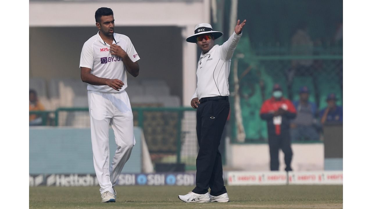 Ravichandran Ashwin (L) with umpire Nitin Menon. Credit: IANS Photo