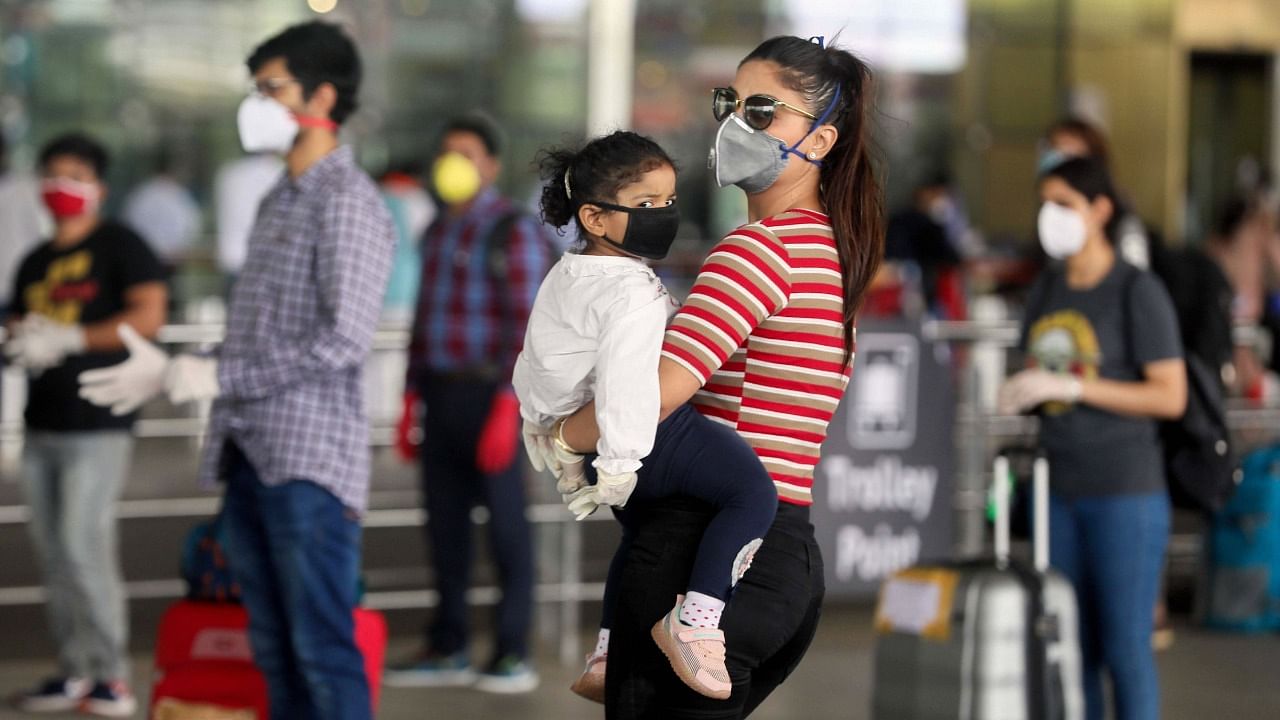 A mother carrying her child waits to enter Shivaji Maharaj International Airport, during the Covid-19 pandemic in Mumbai. Credit: PTI File Photo