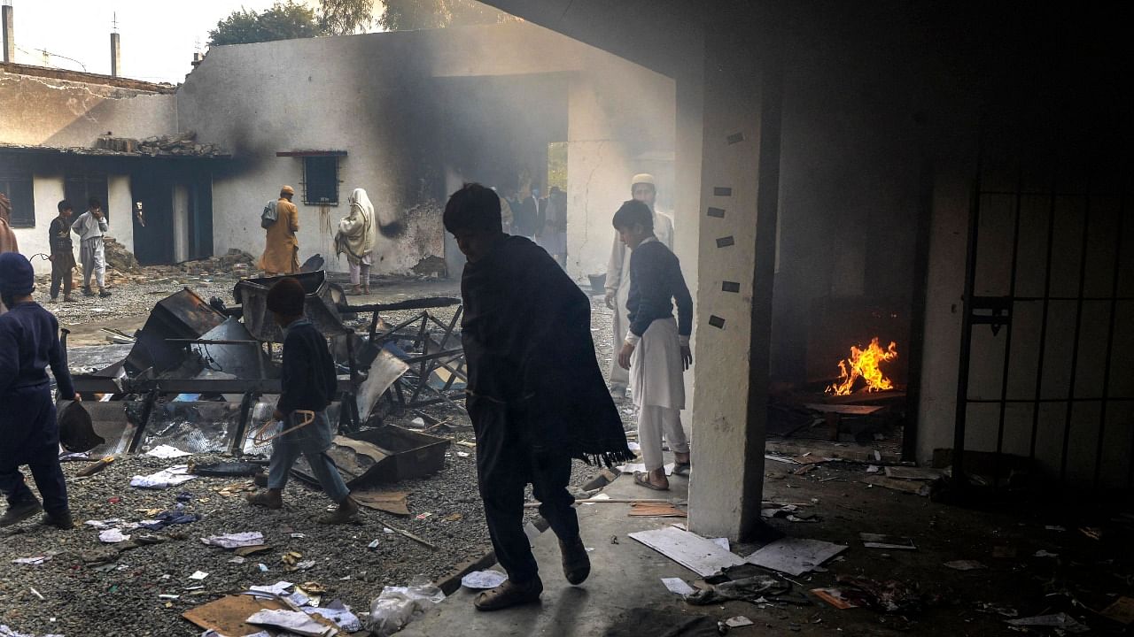 Demonstrators gather at a police station which was set on fire after thousands of people mobbed it demanding that officers hand over a man accused of burning the Koran, in Charsadda, in the Khyber Pakhtunkhwa province. Credit: AFP Photo
