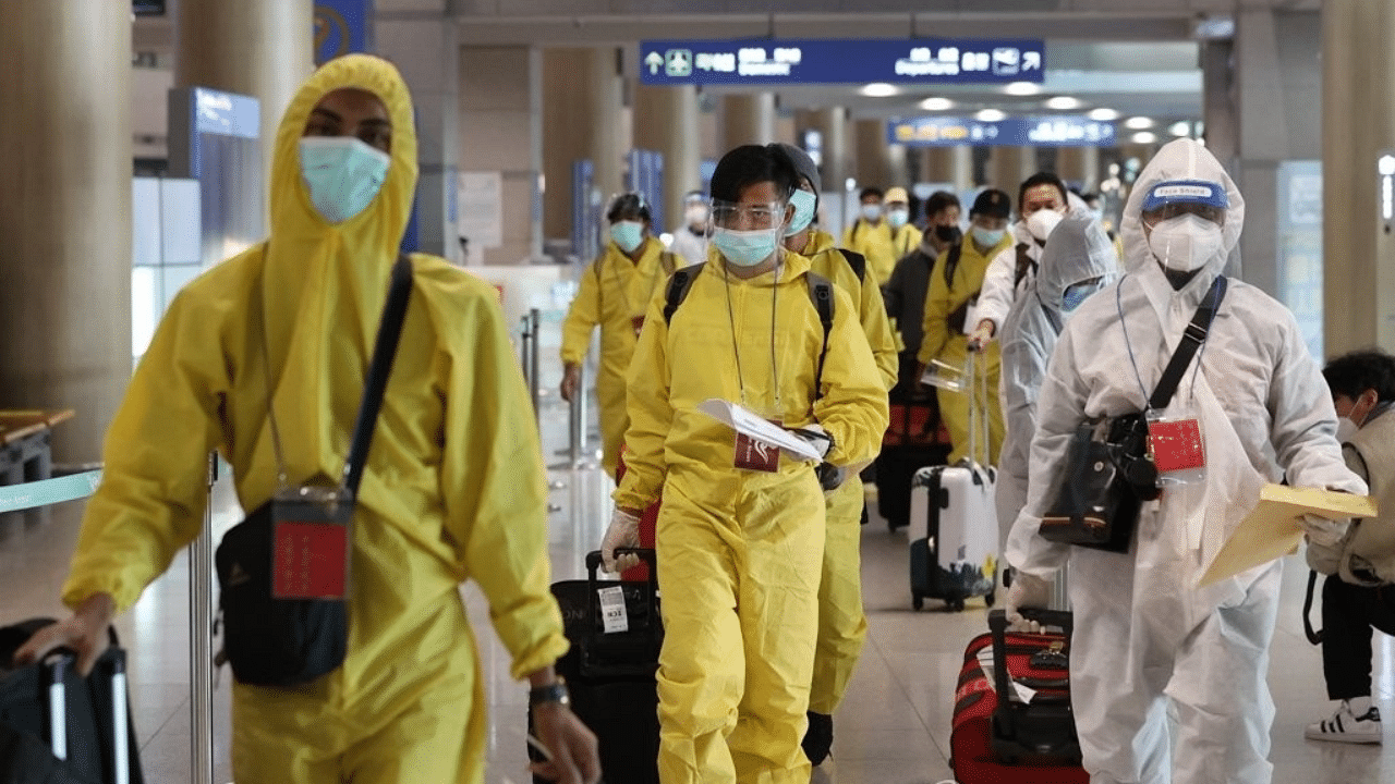 Passengers wearing protective gear arrive at Incheon airport, west of Seoul. Credit: IANS Photo