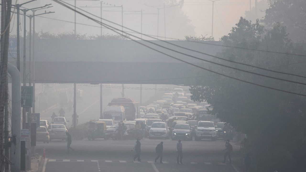 People commute along a street amid smoggy conditions in New Delhi. Credit: AFP File Photo