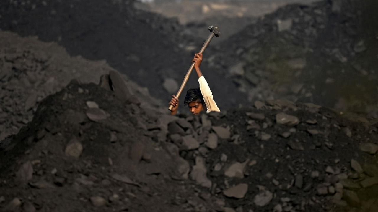 In this file photo taken on November 18, 2021, a labourer works in a coal yard at Singrauli in India's Madhya Pradesh state. Credit: AFP Photo