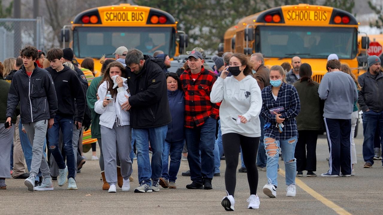 Parents walk away with their kids from the Meijer's parking lot. Credit: Reuters Photo