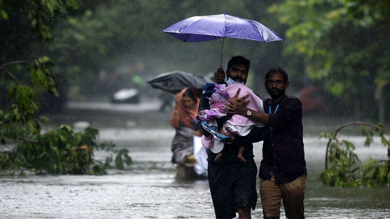 People wade along a waterlogged street during a heavy monsoon rainfall in Chennai on November 11, 2021. Credit: AFP Photo