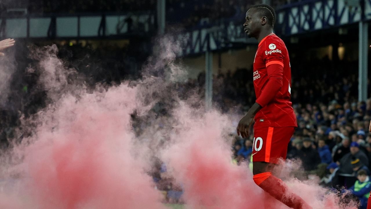 Liverpool's Sadio Mane walks through the smoke from a smoke bomb as he celebrates their third goal. Credit: Reuters Photo