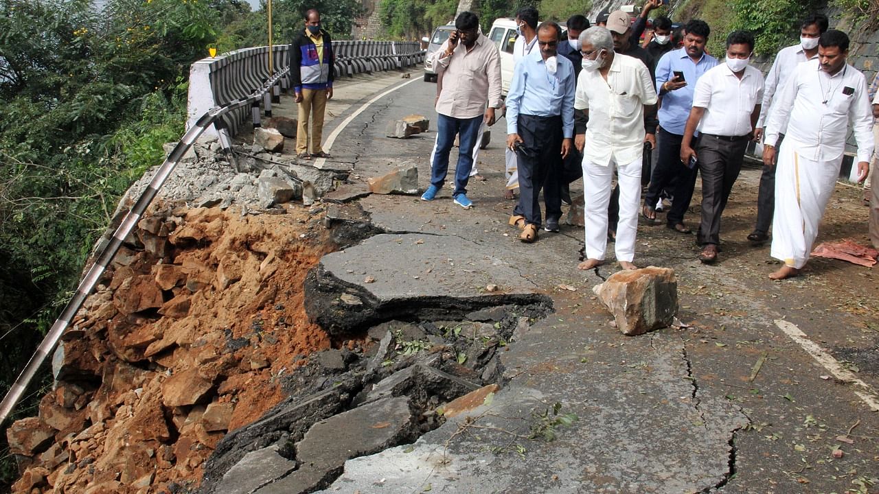 Officials inspect a ghat road destroyed in the recent spell of heavy rains. Credit: PTI Photo