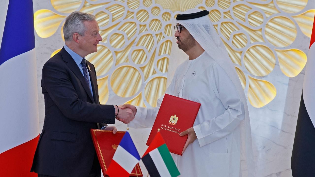 French Economy Minister Bruno Le Maire (L) shakes hands with Emirati Minister of Industry and Advanced Technology Sultan Ahmed al-Jaber after the signing of a bilateral agreement with the United Arab Emirates in Dubai. Credit: AFP Photo