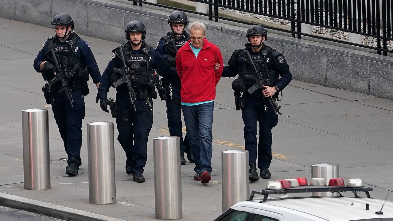 NYPD emergency services personnel escort a man who had been standing outside United Nations headquarters after he surrendered after a standoff. Credit: AP Photo