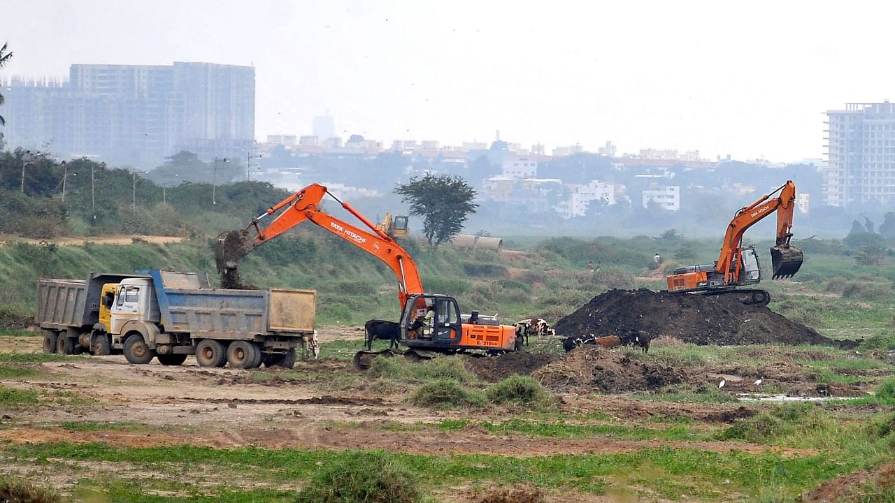 Excavators and trucks make way to rejuvenate the Bellandur Lake in Bengaluru on Thursday. Credit: DH Photo