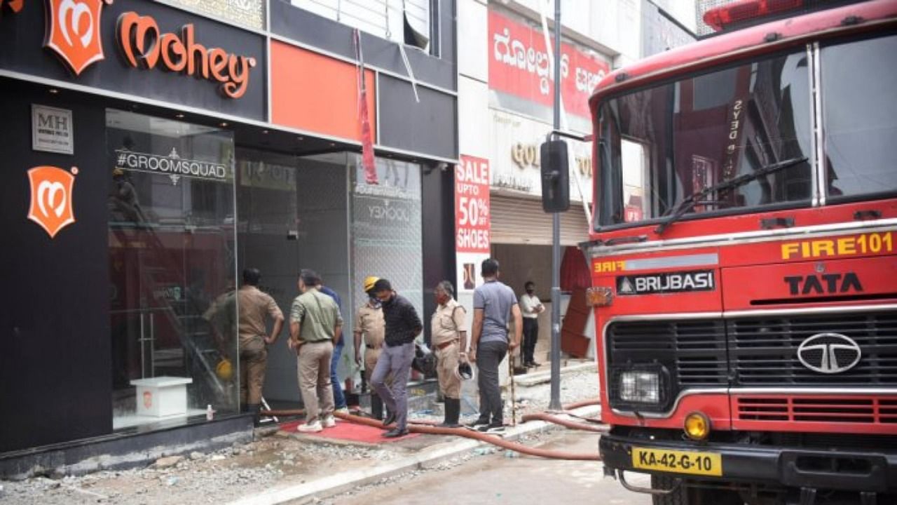 Fire department personnel put out the blaze at the Manyavar Mohey store on Commercial Street on Thursday. Credit: DH Photo