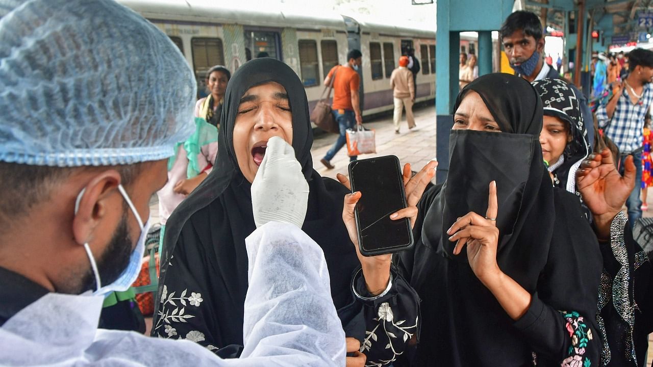 A health worker collects swab sample of a passenger for Covid-19 test, at Dadar railway station, in Mumbai, Thursday, December 2, 2021. Credit: PTI Photo