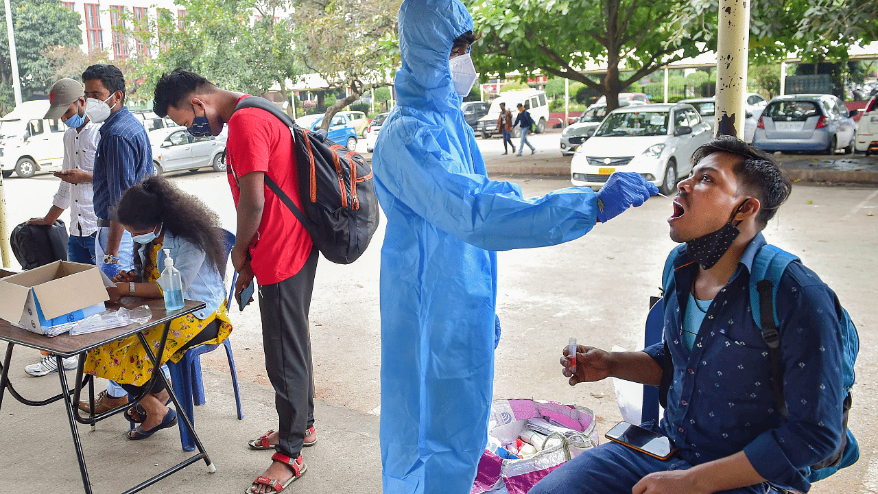 Health worker conducts Covid-19 testing of commuters amid fear of spread of a new variant. Credit: PTI Photo