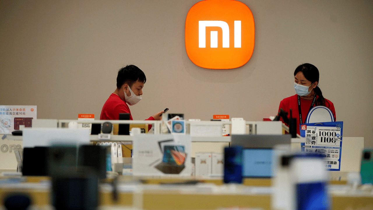 Staff members stand near the company logo at a Xiaomi store in Shanghai. Credit: Reuters Photo