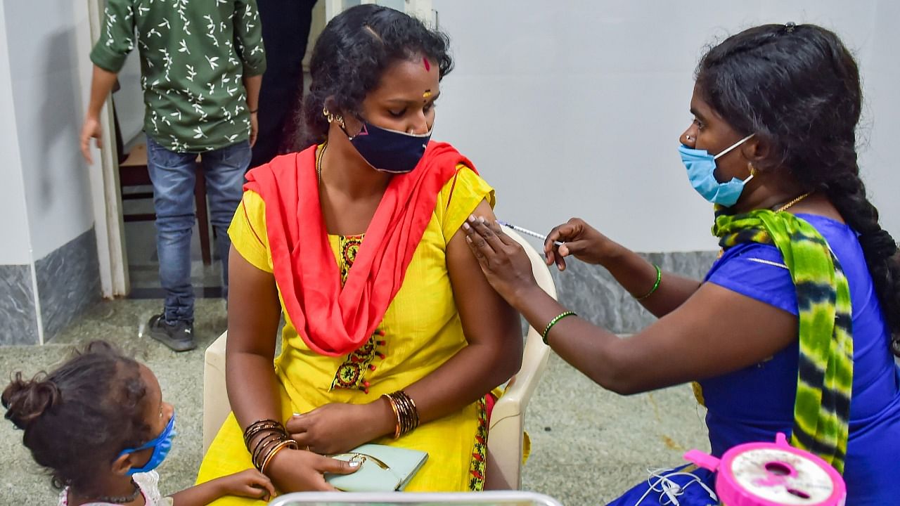 A health worker administers a dose of Covid-19 vaccine to a woman amid fear of spread of a new variant of Covid-19, in Bengaluru. Credit: PTI Photo