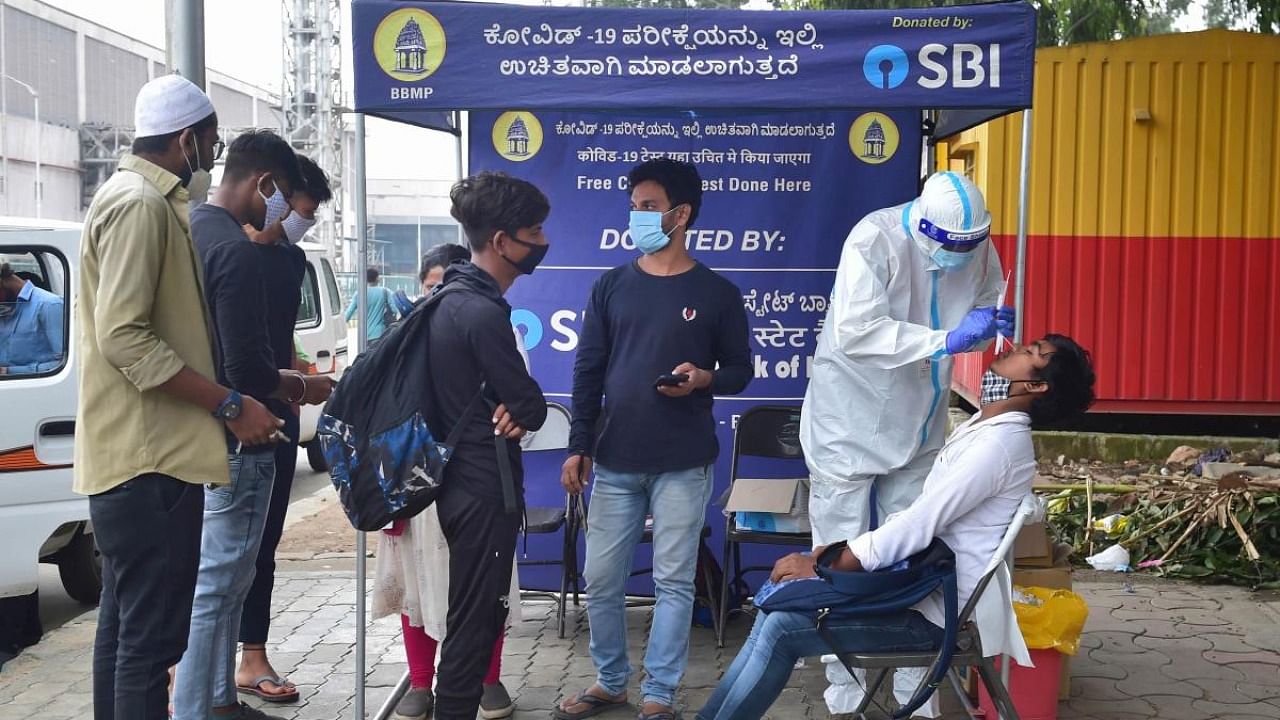 A healthcare worker takes swab sample for Covid-19 tests in Bengaluru. Credit: PTI Photo