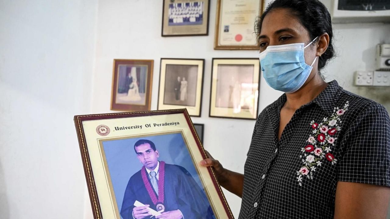 Nilushi Dissanayake the wife of Sri Lankan factory manager who was beaten to death and set ablaze by a mob in Pakistan, holds her husband's graduation photograph at her residence in Ganemulla near Colombo. Credit: AFP Photo