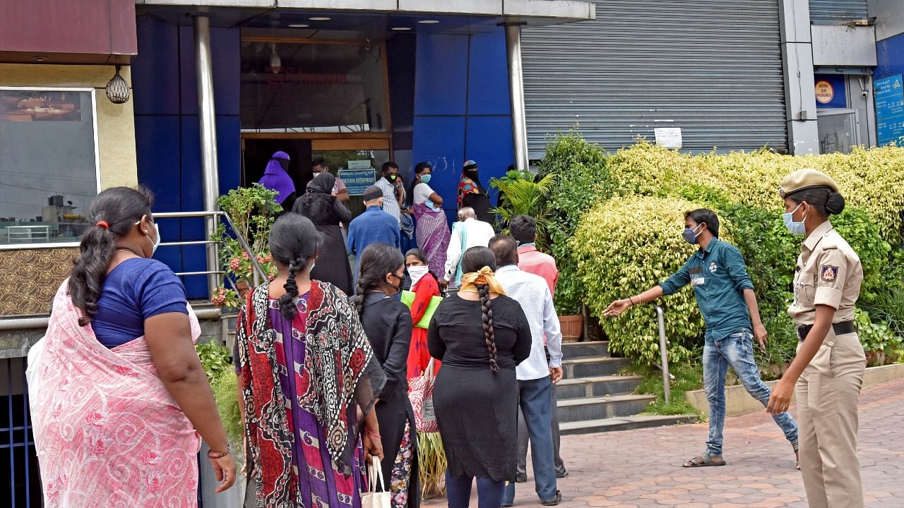 Account holders wait in line to access their accounts under the Central scheme. Credit: DH File Photo