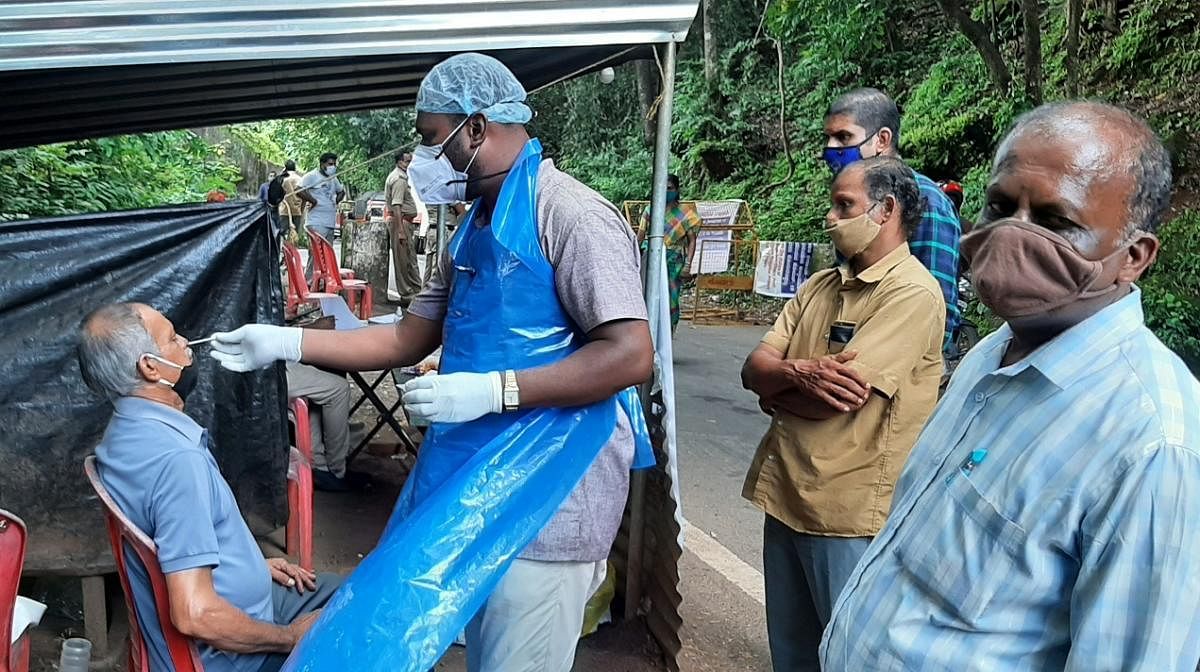 Swab samples being collected by a health official at the Makutta checkpost in Kodagu.