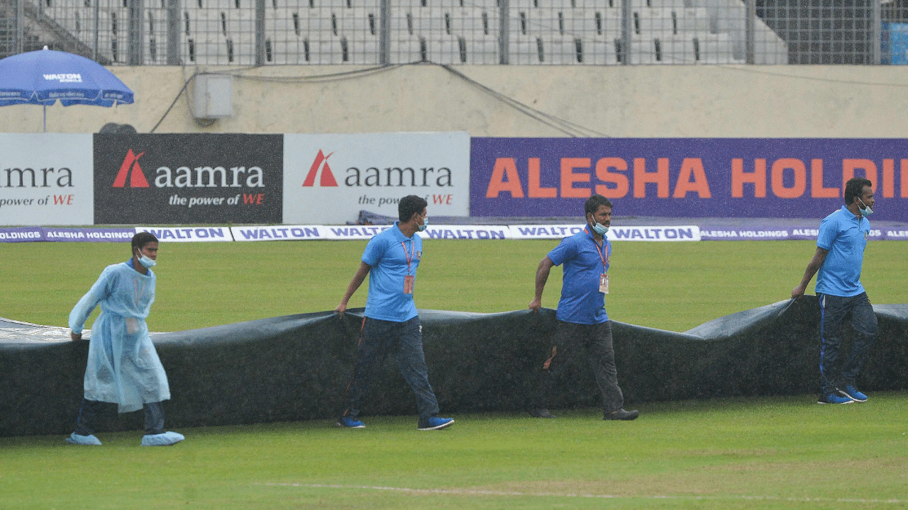 Groundstaff cover the field as it starts to rain on the second day of the second Test cricket match between Bangladesh and Pakistan. Credit: AFP Photo