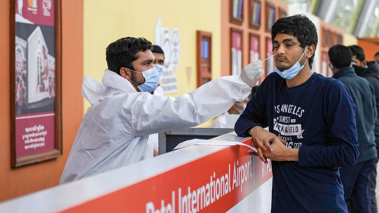 A health worker collects swab sample of a foreign traveler. Credit: PTI Photo