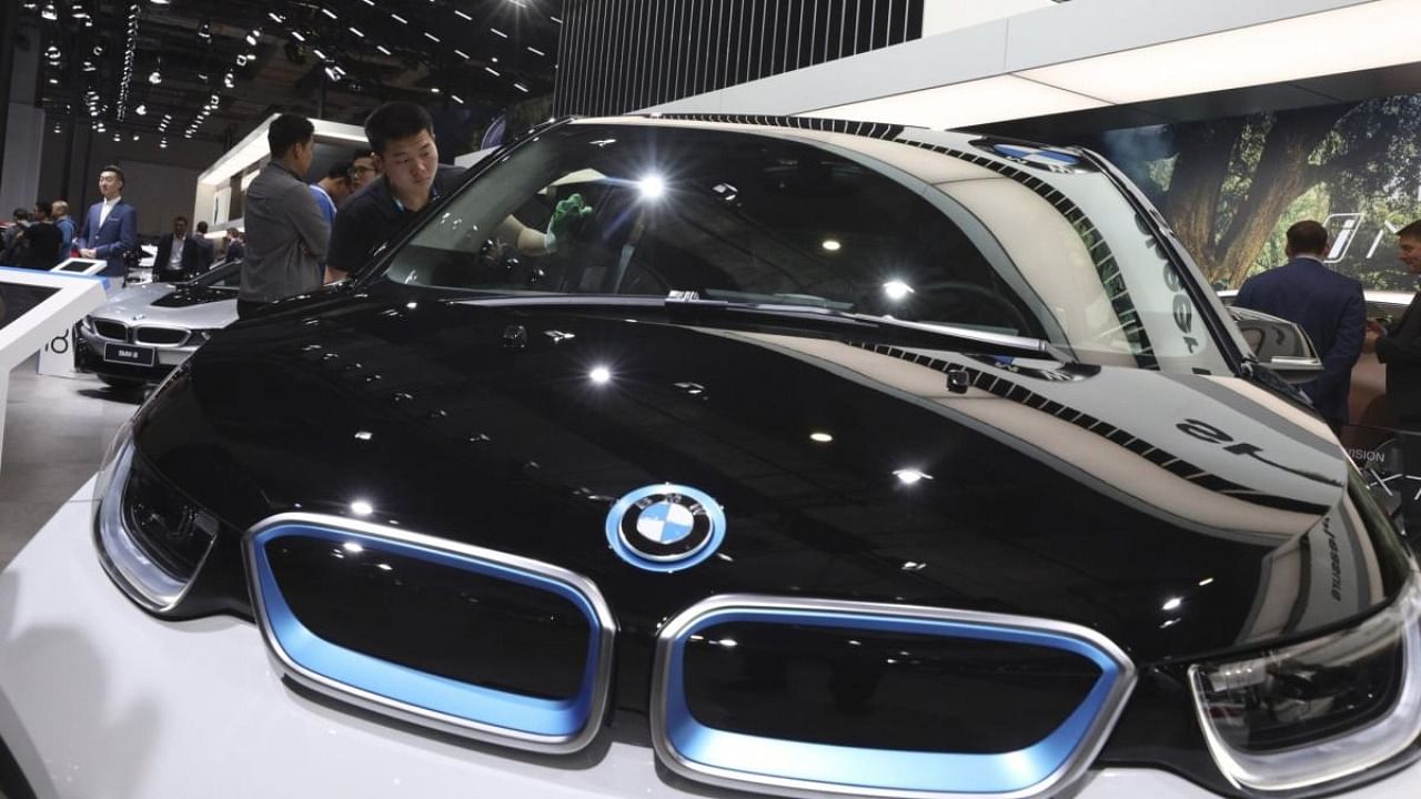 A worker cleans an electric vehicle at the BMW booth during the Auto Shanghai 2019 show in Shanghai Wednesday, April 17, 2019. Credit: AP Photo
