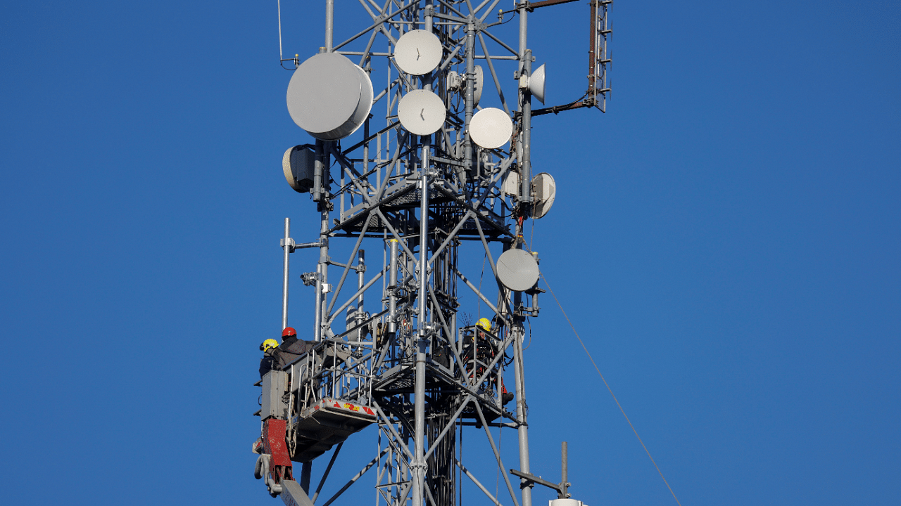 Workers set up a mobile telecom transmitter. Credit: Reuters Photo