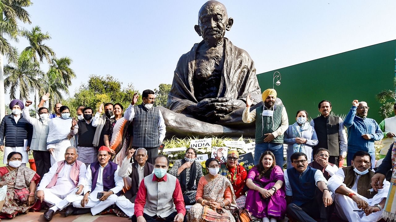 Members of opposition parties along with the suspended MPs at the Gandhi statue in Parliament building. Credit: PTI Photo