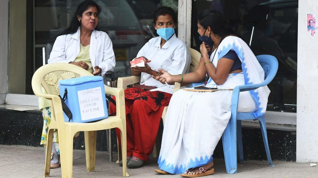 Medical staff waits for people to get inoculated with the Covid-19 coronavirus vaccine during a vaccination drive at a road side in Hyderabad. Credit: AFP file photo