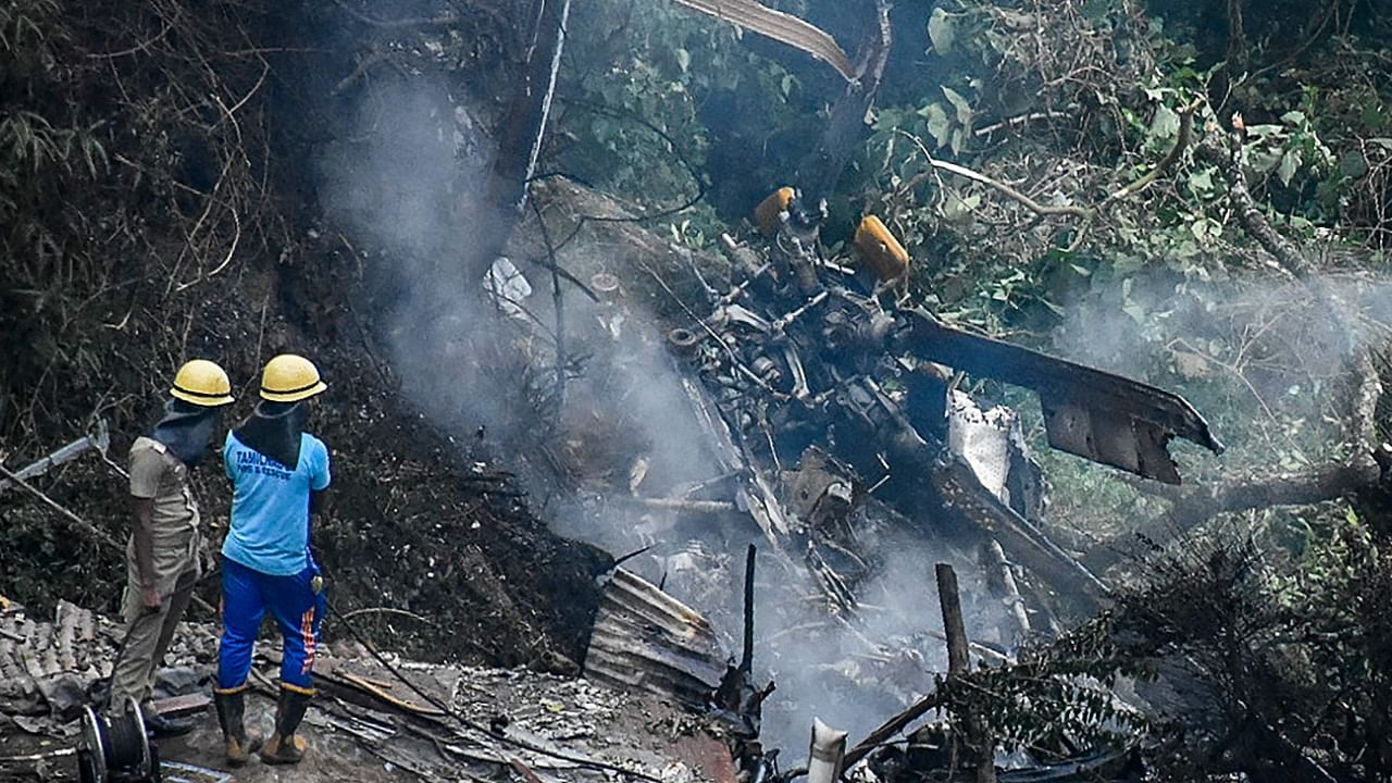 Firemen and rescue workers stand next to the debris of an IAF Mi-17V5 helicopter crash site in Coonoor, Tamil Nadu. Credit: AFP Photo
