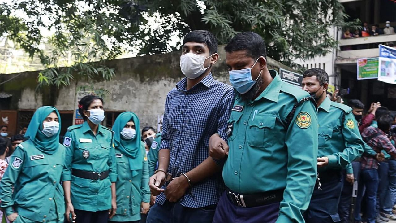 Police escort one of the 20 convicted university students, after their sentence to death for the brutal 2019 murder of a young man who criticised the government on social media, out of a court in Dhaka. Credit: AFP Photo