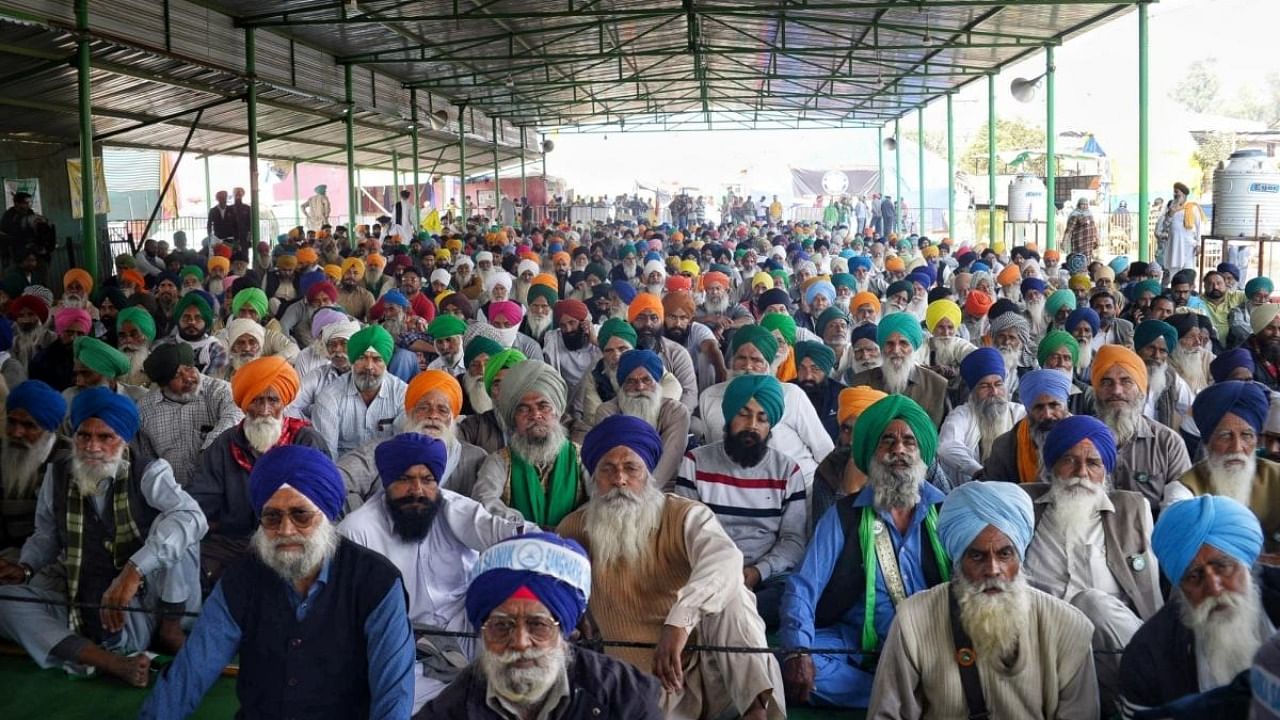 Farmers sit in protest during a rally at Singhu Border in New Delhi. Credit: IANS Photo