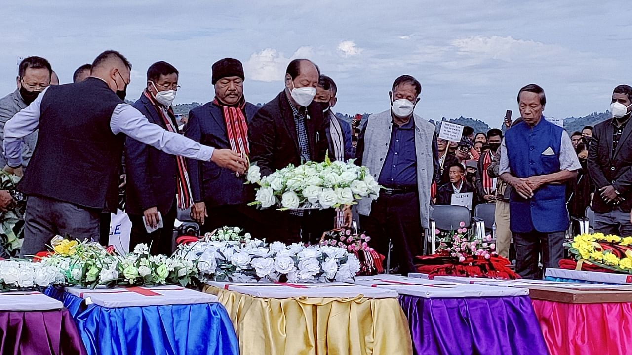 Chief Minister of Nagaland places a wreath on a coffin during a mass funeral of civilians who were mistakenly killed by security forces, in Mon district. Credit: Reuters Photo